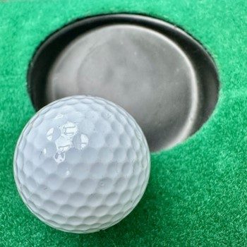 Golfball rollt gezielt und gut dosiert ins Loch