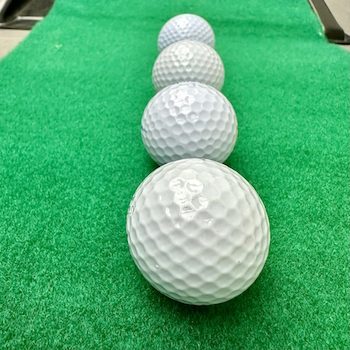 Vier Golfbälle hintereinander auf der Puttingmatte